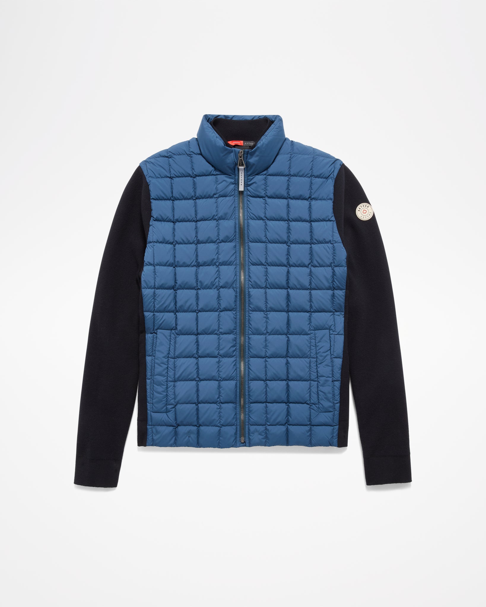 Aspen Collection Aether Phase Men's Full Zip Jacket, in Blue. blue puffer on chest/core of jacket. Black knit sleeves and patch on arm.