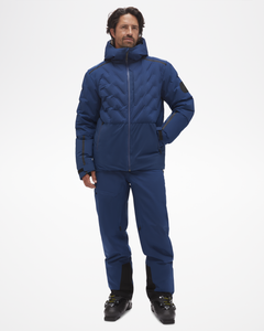 Full body view of powerline jacket with Aspen Collection. Model is wearing matching pants, with ski boots