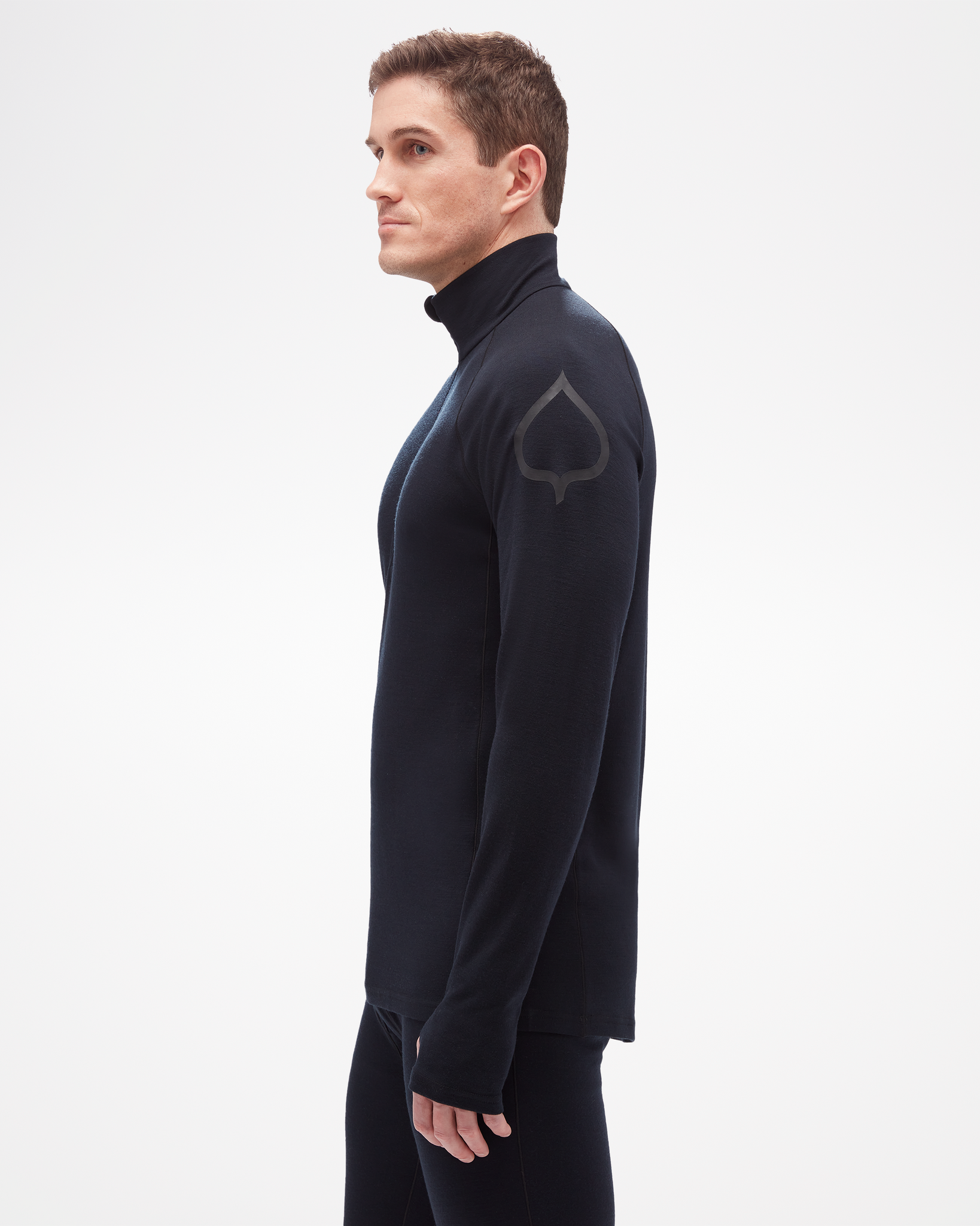 Aspen Collection men's mid layer top, made from merino wool. Side view, focus on aspen leaf logo on arm