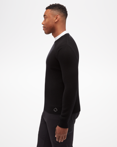 Aspen Collection men's Cashmere Crewneck, simple fitted knit, in black. side view of model, with small aspen leaf logo on bottom.